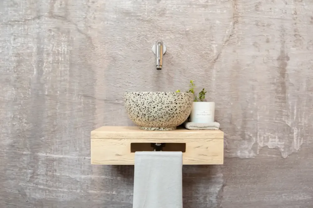 Op = Op Saniclear Seba fonteinset met eiken plank, zwart-witte terrazzo waskom en chromen kraan voor in het toilet
